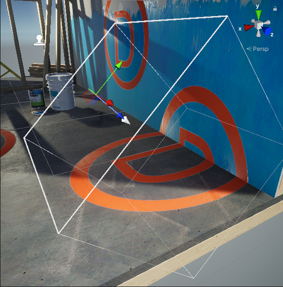 A scene where a Decal Projector projects the letter D onto a floor and wall. The Decal Projector is selected, and a white arrow points from the axis gizmo in the direction of the projection.